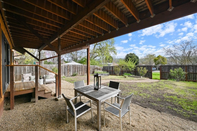 view of yard featuring a fenced backyard, a wooden deck, and outdoor dining space