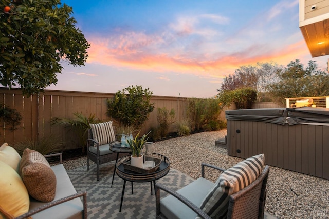 view of patio featuring a fenced backyard, an outdoor living space, and a hot tub