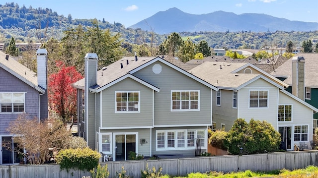 back of house with fence and a mountain view