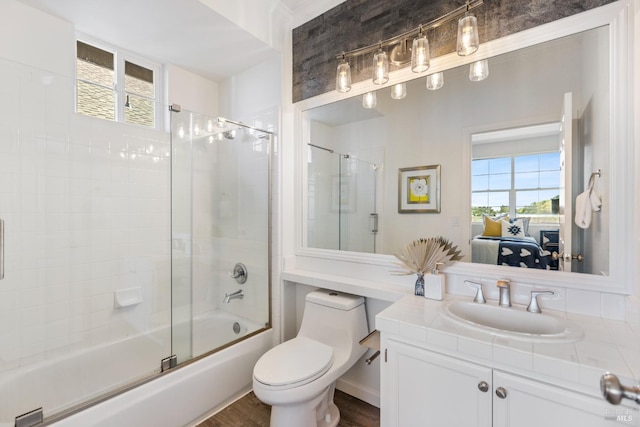 ensuite bathroom featuring plenty of natural light, connected bathroom, bath / shower combo with glass door, and toilet