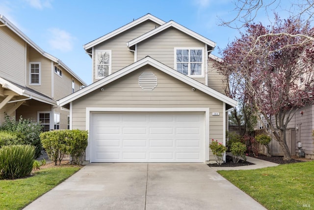 traditional-style house with a garage, driveway, and fence