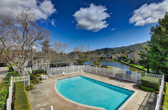 pool featuring a water and mountain view, fence, and a patio