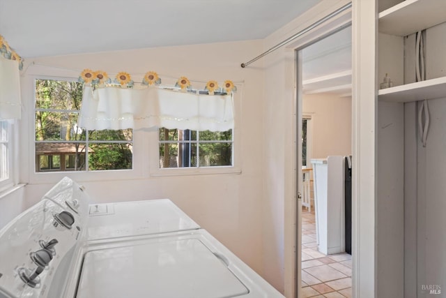 laundry room featuring washing machine and clothes dryer, laundry area, and light tile patterned flooring