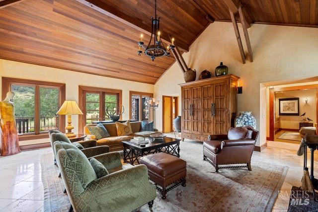 living room featuring a notable chandelier, beam ceiling, high vaulted ceiling, and wood ceiling