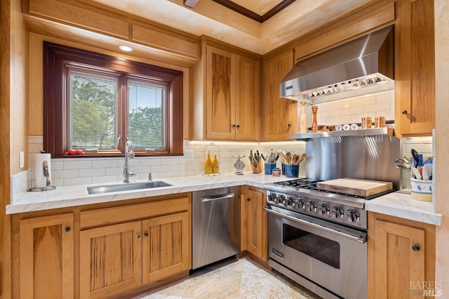 kitchen with decorative backsplash, a sink, stainless steel appliances, light stone countertops, and wall chimney exhaust hood