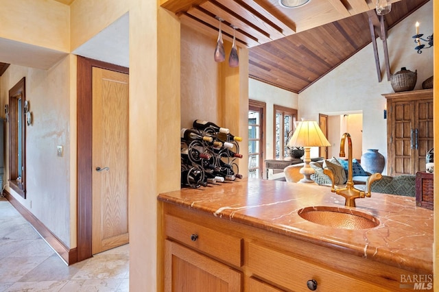 bar featuring wooden ceiling, high vaulted ceiling, and baseboards