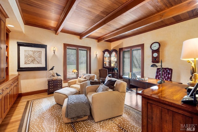 interior space featuring beam ceiling, light wood-type flooring, baseboards, and wooden ceiling