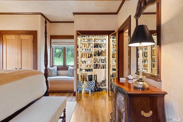 bedroom featuring crown molding and light wood finished floors