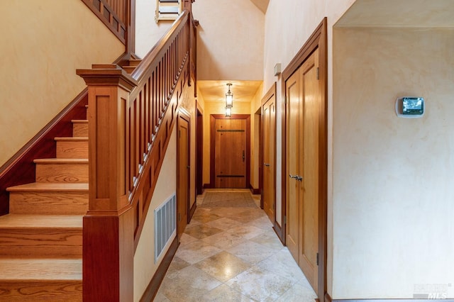 stairs featuring a high ceiling and visible vents