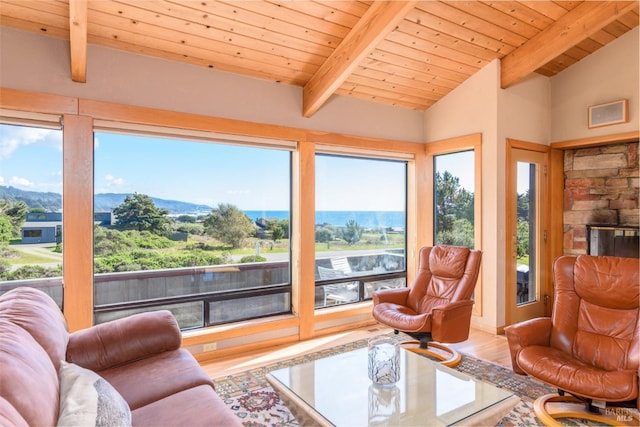 living area featuring vaulted ceiling with beams, wood finished floors, and wooden ceiling
