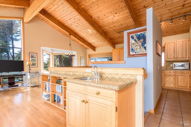 kitchen featuring open shelves, beam ceiling, a sink, and light brown cabinets