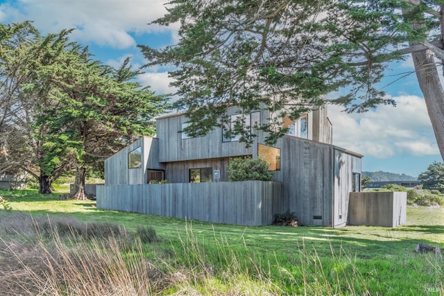 view of side of property featuring a lawn, an outbuilding, and crawl space