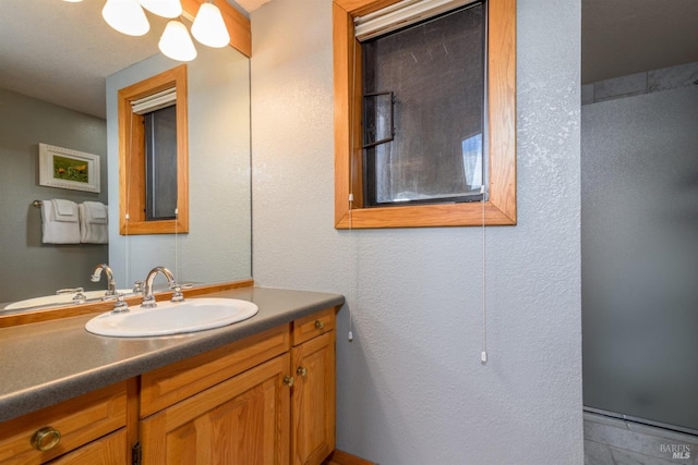 bathroom featuring a textured wall and vanity