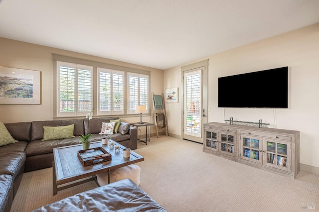 carpeted living area featuring baseboards