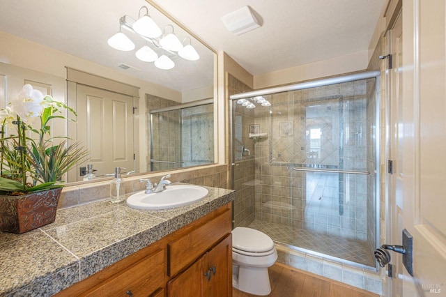 full bath featuring visible vents, a stall shower, toilet, wood finished floors, and vanity