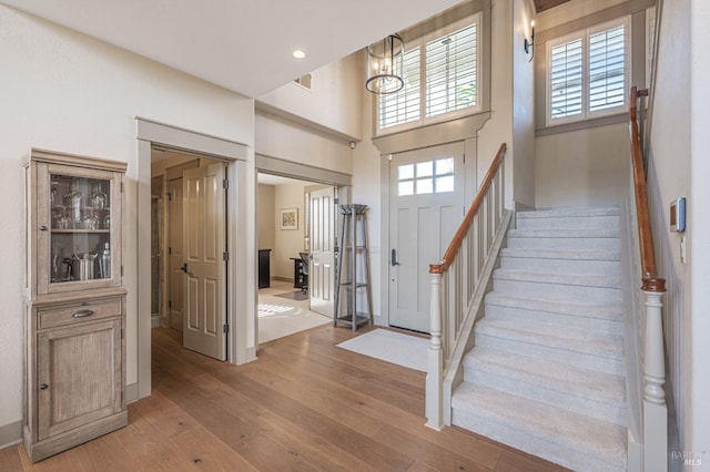 entryway featuring stairway, a healthy amount of sunlight, and light wood finished floors
