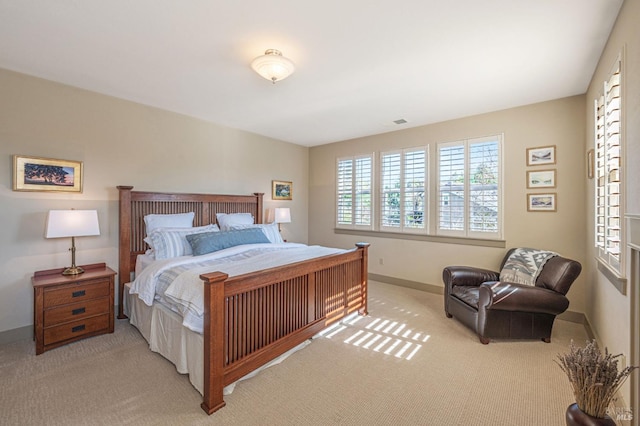 bedroom with baseboards and light colored carpet