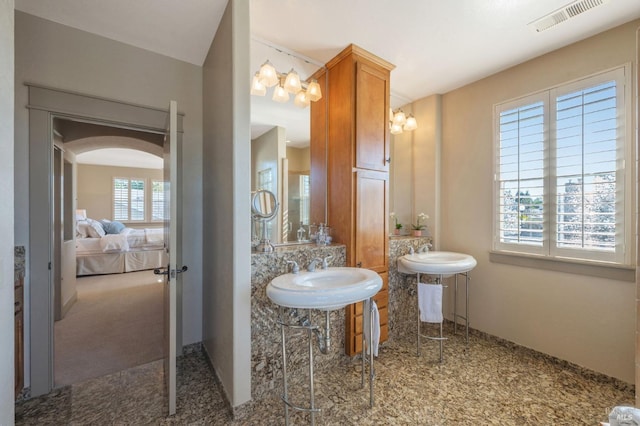 bathroom featuring a sink, baseboards, ensuite bath, and visible vents