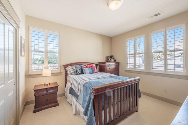 carpeted bedroom with visible vents and baseboards