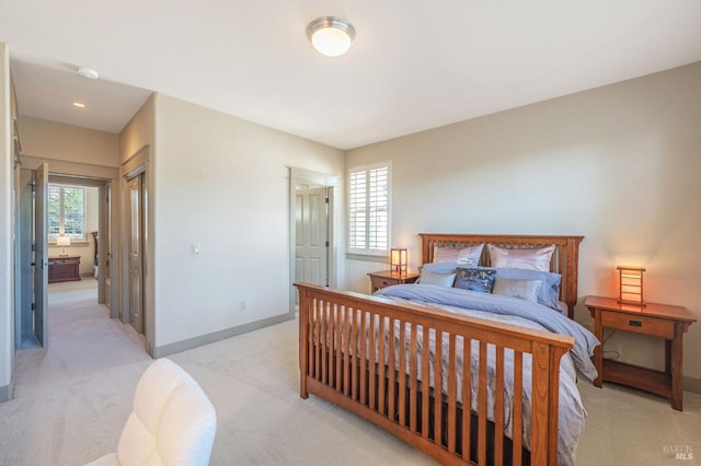bedroom with baseboards and light carpet