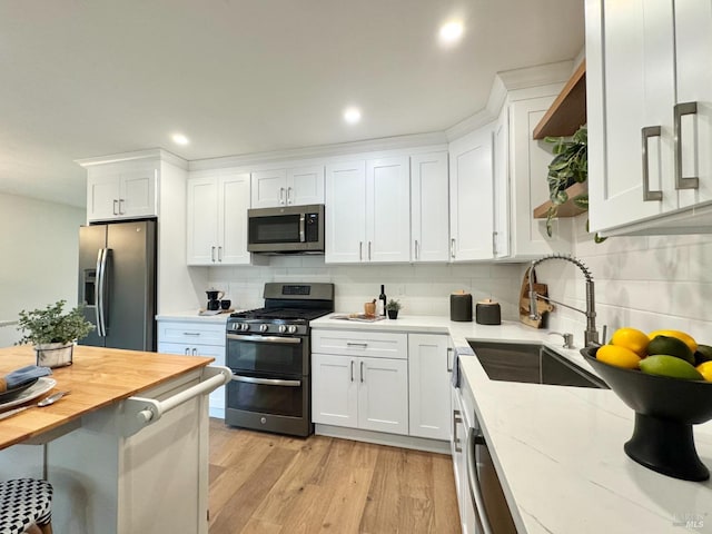 2131 1st Ave, Napa, CA 94558 - kitchen featuring white cabinets, backsplash, appliances with stainless steel finishes, and a sink