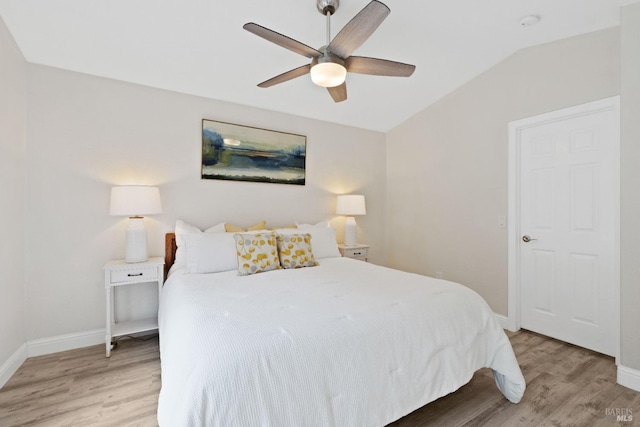 bedroom featuring lofted ceiling, baseboards, and light wood-type flooring