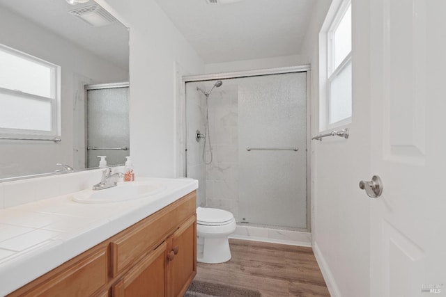 full bath featuring vanity, toilet, visible vents, and a stall shower