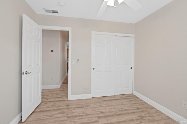 unfurnished bedroom with light wood-style floors, visible vents, a closet, and baseboards