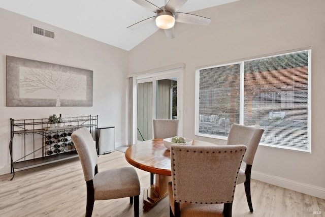 dining space with visible vents, baseboards, light wood-type flooring, lofted ceiling, and a ceiling fan
