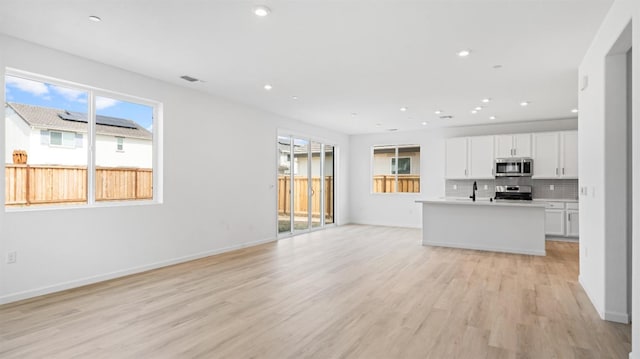 1059 Jarup Dr, Lathrop, CA 95330 - unfurnished living room with plenty of natural light, light wood finished floors, recessed lighting, and a sink