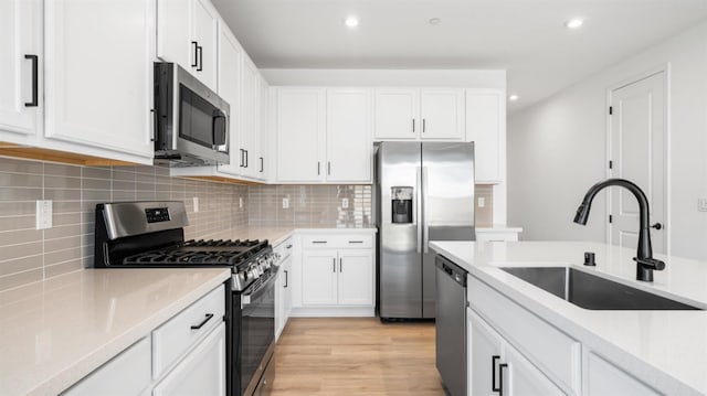 1059 Jarup Dr, Lathrop, CA 95330 - kitchen featuring tasteful backsplash, appliances with stainless steel finishes, light countertops, a sink, and white cabinetry