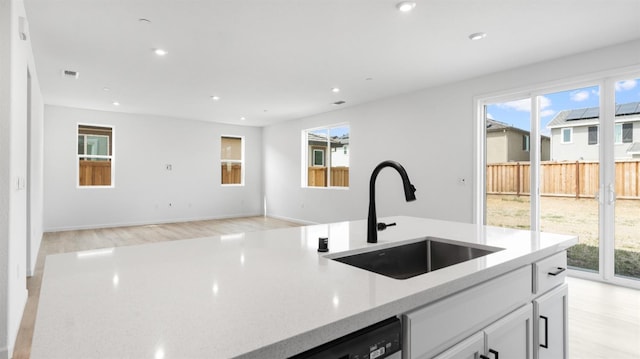 1059 Jarup Dr, Lathrop, CA 95330 - kitchen with white cabinetry, recessed lighting, light wood-style floors, and a sink