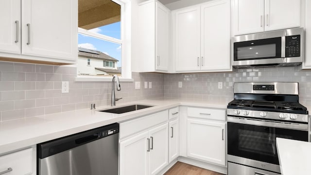 kitchen with white cabinetry, a sink, appliances with stainless steel finishes, and light countertops