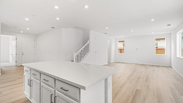kitchen featuring a center island, recessed lighting, open floor plan, and light wood-type flooring