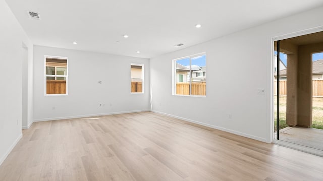 empty room featuring visible vents, light wood-type flooring, recessed lighting, and baseboards