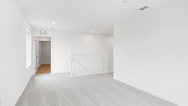 carpeted spare room with baseboards, visible vents, and recessed lighting