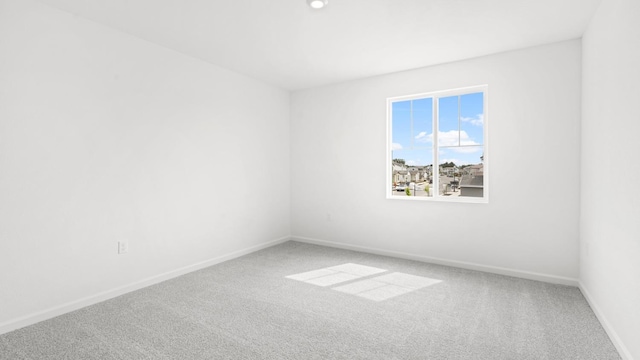 carpeted empty room with baseboards