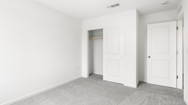 unfurnished bedroom featuring visible vents, a closet, baseboards, and carpet floors