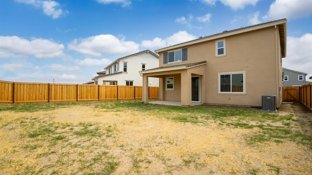 rear view of house featuring cooling unit, a patio, stucco siding, and a fenced backyard