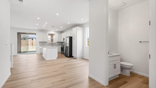kitchen featuring stainless steel appliances, light countertops, white cabinets, and baseboards