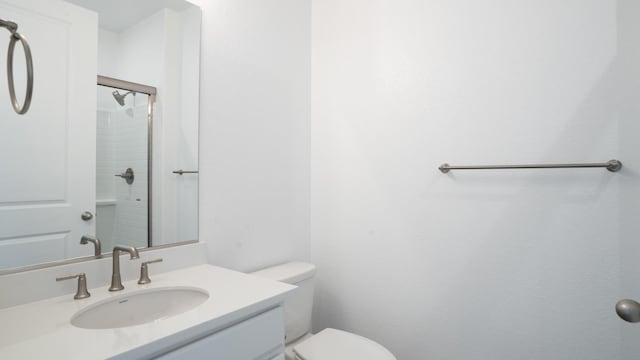 full bath featuring toilet, walk in shower, and vanity