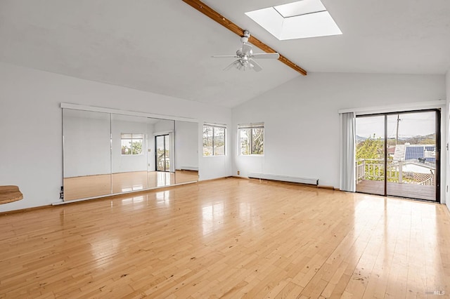 spare room featuring beam ceiling, a skylight, wood-type flooring, and a baseboard radiator