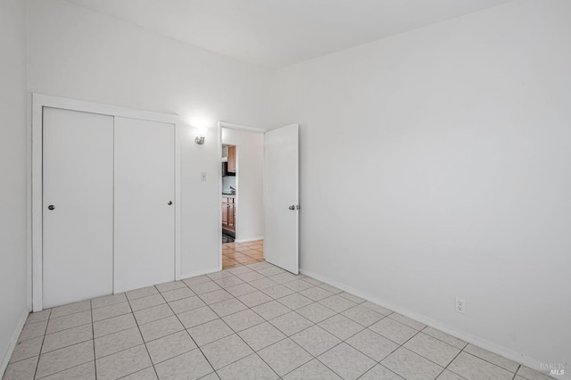 unfurnished bedroom with a closet and light tile patterned flooring