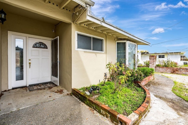 property entrance with stucco siding