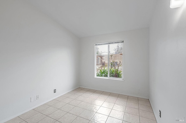 spare room featuring light tile patterned floors and baseboards