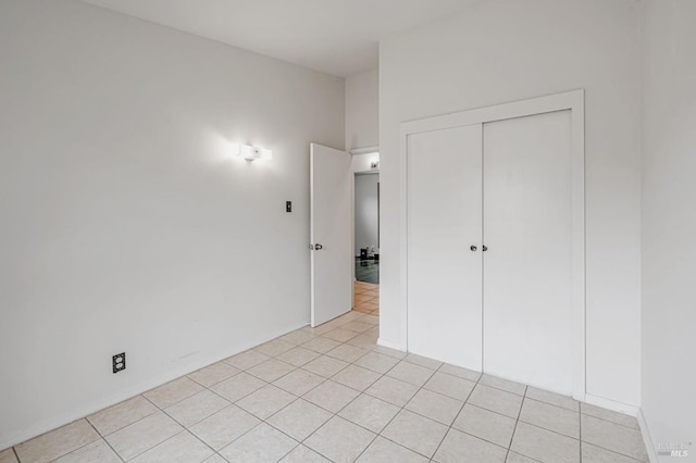 unfurnished bedroom featuring a closet and light tile patterned flooring