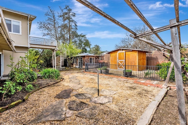 view of yard with an outdoor structure, stairs, and fence