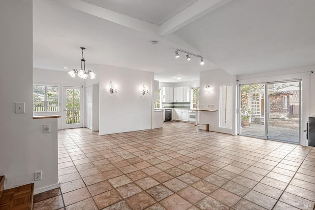 unfurnished living room featuring a wealth of natural light, baseboards, lofted ceiling with beams, and an inviting chandelier