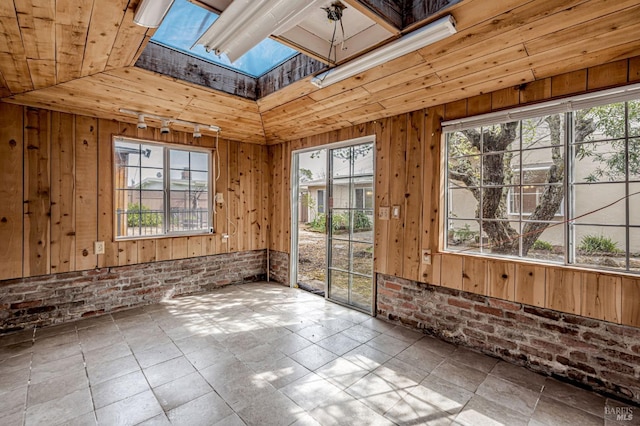 unfurnished sunroom featuring a skylight