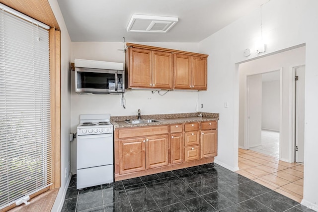 kitchen featuring lofted ceiling, a sink, stainless steel microwave, white electric range, and brown cabinets